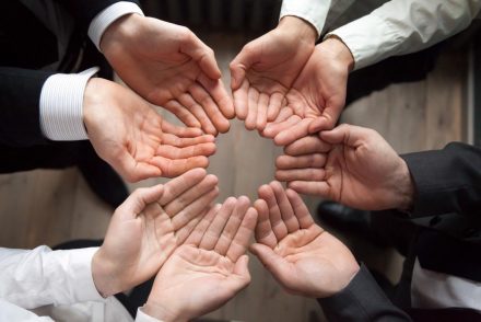 Várias mãos de empresários unidas em círculo: tipos de crowdfunding